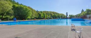 a large swimming pool with two chairs in a park at Wonderful Renovated Apartment With Great Location in Kaiserslautern