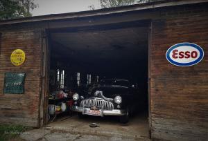 un coche viejo está aparcado dentro de un garaje en Kvarnbo Pensionat, en Saltvik