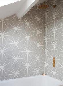 uma casa de banho com azulejos hexágonos brancos e cinzentos em Stunning studio cntrl Totnes with parking em Totnes