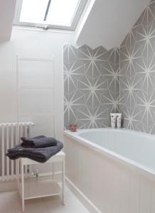 een witte badkamer met een bad en een raam bij Stunning studio cntrl Totnes with parking in Totnes