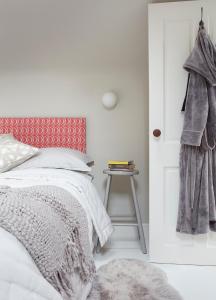 - une chambre avec un lit et un tabouret à côté d'une porte dans l'établissement Stunning studio cntrl Totnes with parking, à Totnes