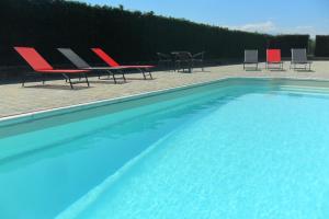 a group of chairs and a swimming pool at VILLA BOTTERA - Jacuzzi & Private Garden in Riforano