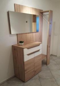 a bathroom with a wooden vanity with a mirror at Christl's Ferienwohnung in Marktoberdorf
