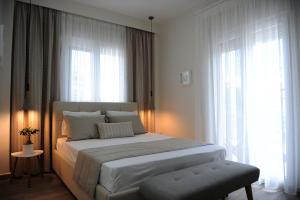 Schlafzimmer mit einem großen weißen Bett und Fenstern in der Unterkunft Stamatia Apartments in Asprovalta