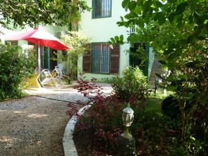 a garden with a red umbrella and a building at Lodge Takini 4 in Kourou