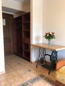 a room with a table with a vase of flowers on it at Pokoje gościnne Bursztynowa in Białogóra