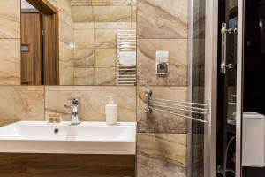 a bathroom with a sink and a mirror at TatryTop Apartamenty Zaciszne in Zakopane +39 photos