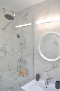 een badkamer met een douche, een wastafel en een spiegel bij Belém River Apartment in Lissabon