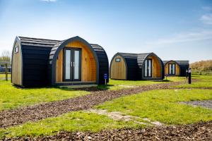 a row of tiny houses in a field at Camping Pods, Golden Sands Holiday Park in Dawlish