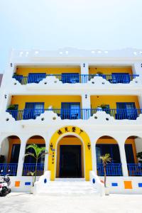 um prédio amarelo com varandas azuis em Yujian Kending Tese Homestay em Kenting