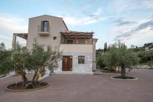 uma grande casa branca com árvores em frente em Nafplia Terra em Nafplio