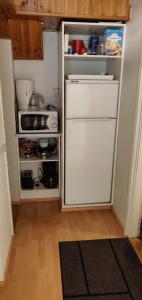 a small kitchen with a refrigerator and a microwave at Cozy Cityhome Pirkankatu in Tampere
