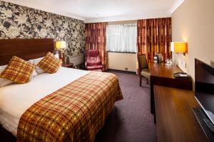 a hotel room with a bed and a desk at Mercure Livingston Hotel in Livingston