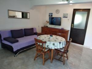 uma sala de estar com uma mesa e um sofá em Holiday Home Ena , Mali Iž 286 em Mali Iz