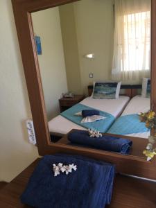 two twin beds in a room with a mirror at Dionisos Blue in Paralia Dionysiou