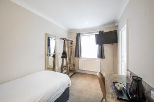 a bedroom with a bed and a desk and a window at Half Moon, Sherborne by Marston's Inns in Sherborne