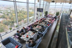 un grupo de personas sentadas en mesas en un restaurante en Hotel Korston Royal Kazan, en Kazán