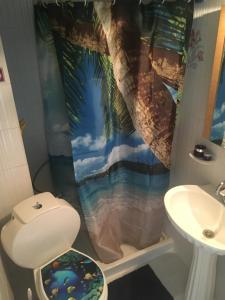 a bathroom with a palm tree shower curtain at Dionisos Blue in Paralia Dionysiou +33 photos