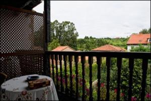 a table on a balcony with a view of a yard at Posada Ansorena in Santillana del Mar
