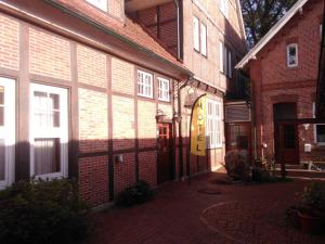 un callejón en un viejo edificio de ladrillo con una puerta amarilla en Alte Kornbrennerei GBR en Poggenort