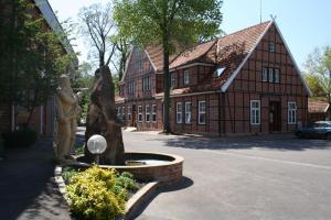 a statue of a woman in front of a building at Alte Kornbrennerei GBR in Poggenort