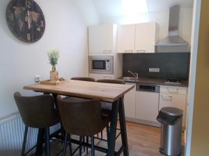 a small kitchen with a wooden table and chairs at Heidehof Hellenthal in Hellenthal
