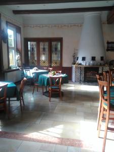 a dining room with tables and chairs and a fireplace at Alte Kornbrennerei GBR in Poggenort