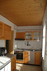 a kitchen with wooden cabinets and a stove top oven at Gästehaus Mea Vota in Braunlage