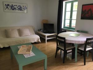 een woonkamer met een tafel en een bank bij allees des soupirs in Cahors