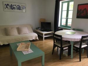 una sala de estar con una mesa y un sofá en allees des soupirs, en Cahors