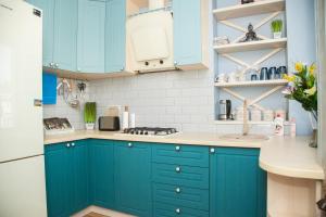 a kitchen with blue cabinets and a sink at VIP Apartment on Lobanovskogo 19 Street in Zaporozhye