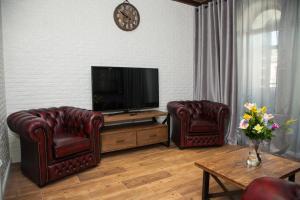 uma sala de estar com 2 cadeiras e uma televisão de ecrã plano em VIP Apartment on Lobanovskogo 19 Street em Zaporizhzhya