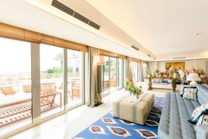 a living room with a couch and large windows at The Albatroz Hotel in Cascais