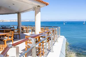 a restaurant overlooking the ocean with tables and chairs at The Albatroz Hotel in Cascais