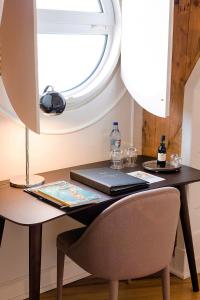a table with a laptop and a window at The Albatroz Hotel in Cascais