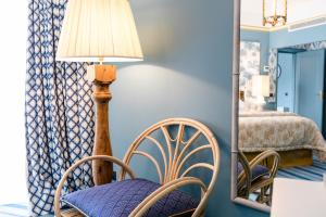 a room with a chair and a lamp and a mirror at The Albatroz Hotel in Cascais