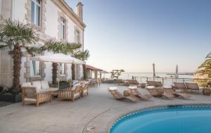 a resort with a swimming pool and chairs and a building at The Albatroz Hotel in Cascais