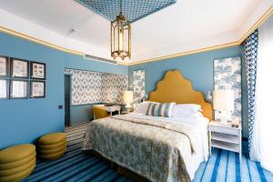 a bedroom with a large bed and blue walls at The Albatroz Hotel in Cascais