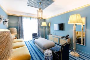 a hotel room with blue walls and a bed and a couch at The Albatroz Hotel in Cascais