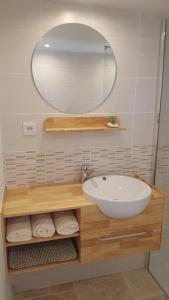 a bathroom with a sink and a mirror and towels at Gite aux Lauriers d'Adhémar in La Garde-Adhémar