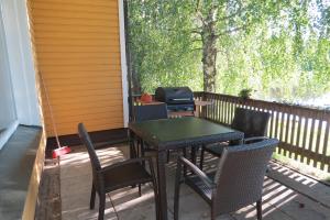 un patio avec une table, des chaises et un grill dans l'établissement Laatokan Portti Apartments, à Parikkala