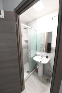 um banheiro com uma pia branca e um chuveiro em AFFITTACAMERE A CASA MIA em Roma mais 76 fotografias