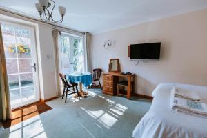 a bedroom with a bed and a tv and a table at Bluebell House in Windsor