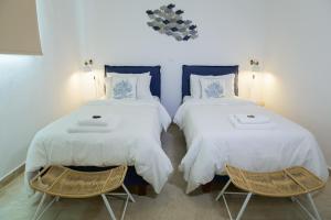 Blue Fort Villas في ميثوني: سريرين في غرفة مع كرسيين