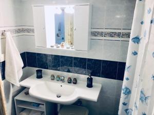 une salle de bains avec un lavabo blanc et un miroir dans l'établissement Atlantida Spacious Flat, à Fira 59 autres photos