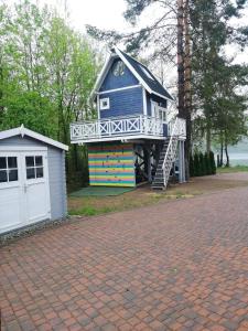 Cette petite maison bleue dispose d'une terrasse couverte et d'un escalier. dans l'établissement Jezioro Marzeń na Kaszubach, à Stare Czaple