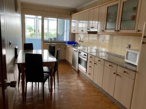 a kitchen with a table and chairs and a counter top at Apartamento Naron in Narón