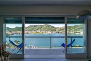 Zimmer mit 2 Stühlen und Blick auf das Wasser in der Unterkunft Como Unbelievable View - The House Of Travelers in Como