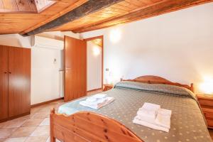 a bedroom with a wooden bed with towels on it at Agriturismo La Filanda in Manerba del Garda