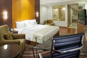 a hotel room with a bed and a glass table at Holiday Inn Mumbai International Airport, an IHG Hotel in Mumbai
